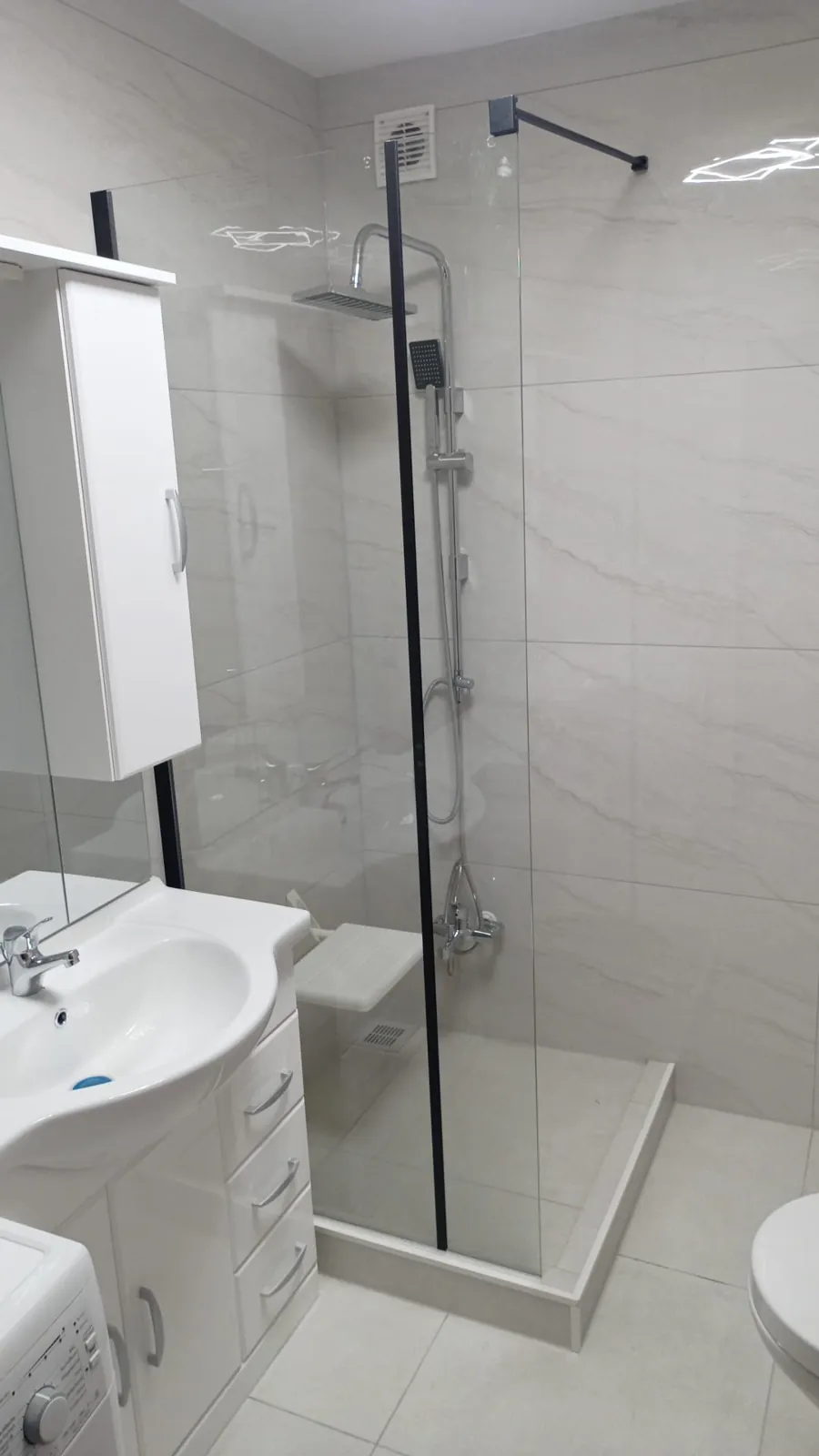 Modernes Bad mit Glasdusche nach der Sanierung.