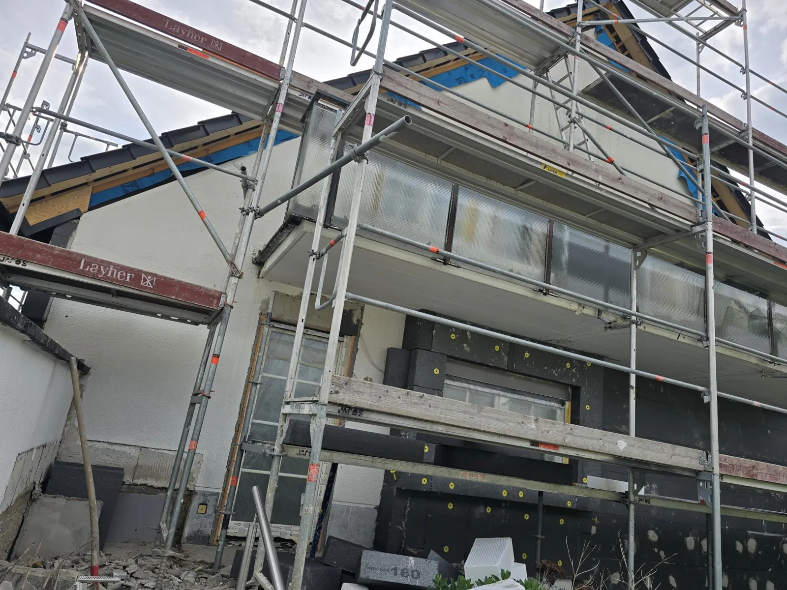 Fassaden- und Dachsanierung mit Gerüst an einem Wohnhaus.