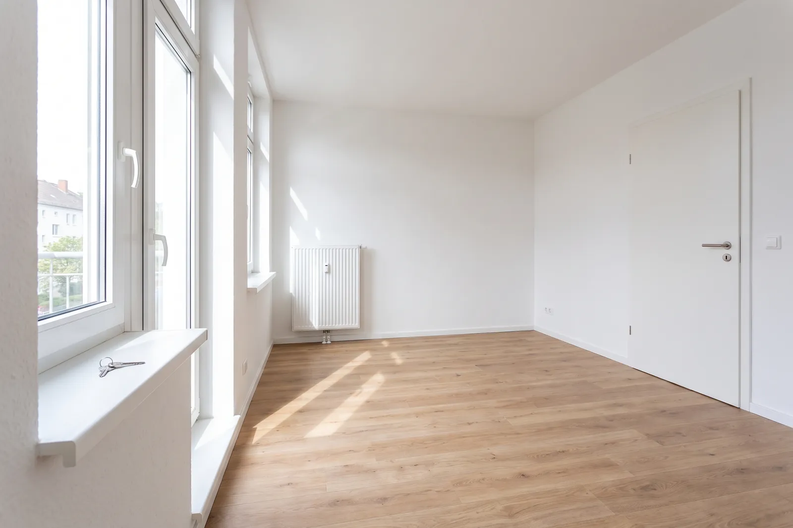 Frisch renovierte, leere Mietwohnung mit neuem Boden und weißen Wänden vor der Übergabe.
